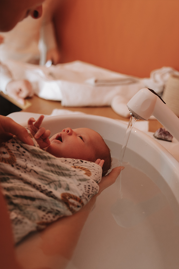 Bébé dans un bain enveloppé - photo de naissance en Seine-et-Marne Camille Boutoux